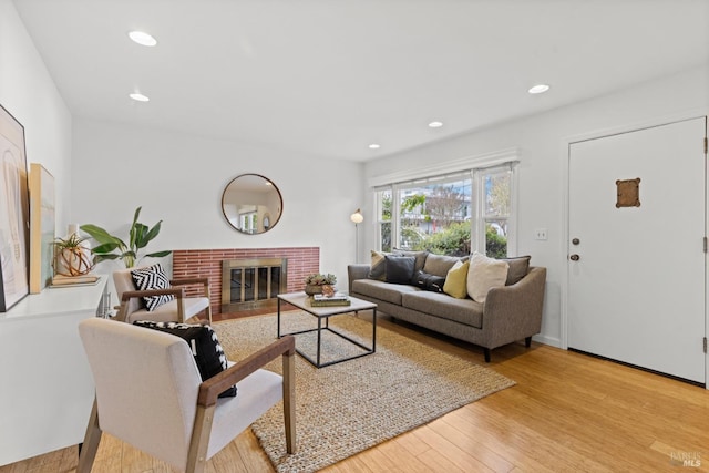 living room featuring recessed lighting, wood finished floors, and a fireplace