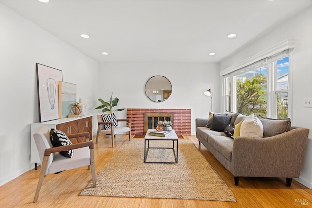 living room featuring a brick fireplace, recessed lighting, wood finished floors, and baseboards