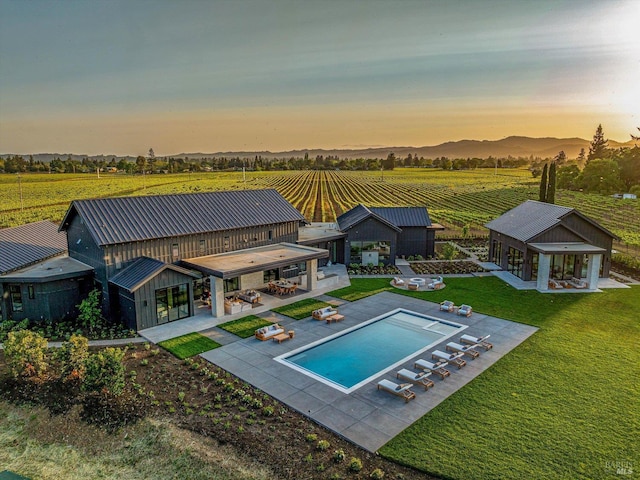 2350 Big Ranch Rd, Napa, CA 94558 - back of property at dusk with a view of countryside, an outdoor structure, a patio area, an outdoor pool, and an exterior structure