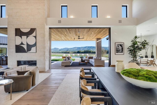 2350 Big Ranch Rd, Napa, CA 94558 - living area with a mountain view, wood finished floors, healthy amount of natural light, a stone fireplace, and a high ceiling