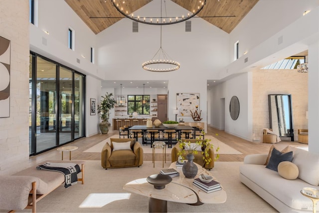 living room with wooden ceiling, visible vents, plenty of natural light, and an inviting chandelier