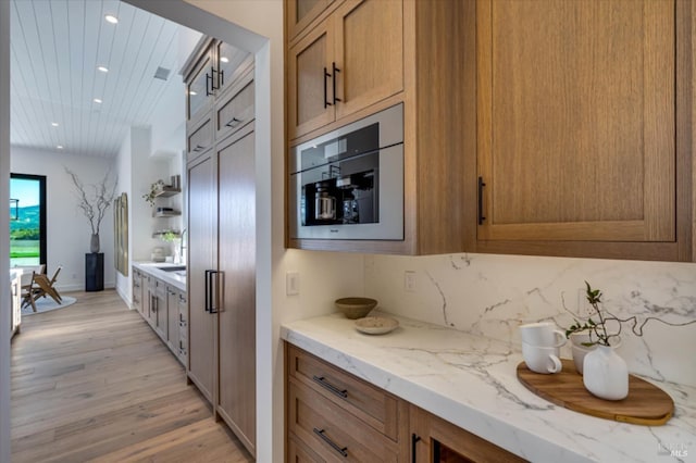 2350 Big Ranch Rd, Napa, CA 94558 - kitchen with recessed lighting, light wood finished floors, brown cabinets, light stone counters, and a sink