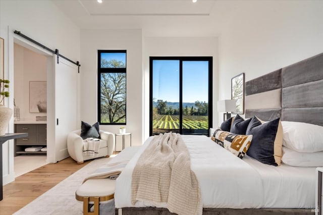2350 Big Ranch Rd, Napa, CA 94558 - bedroom featuring a barn door, light wood finished floors, ensuite bathroom, and recessed lighting