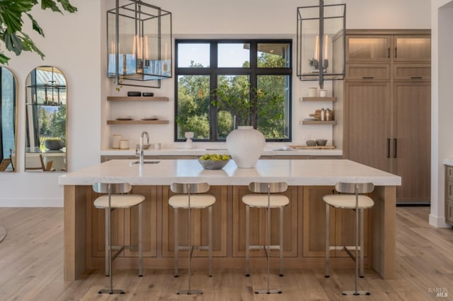 2350 Big Ranch Rd, Napa, CA 94558 - kitchen with open shelves, a sink, light wood finished floors, an island with sink, and hanging light fixtures