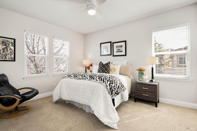 bedroom featuring light carpet, a ceiling fan, and baseboards