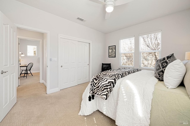 bedroom featuring a closet, visible vents, carpet flooring, ceiling fan, and baseboards