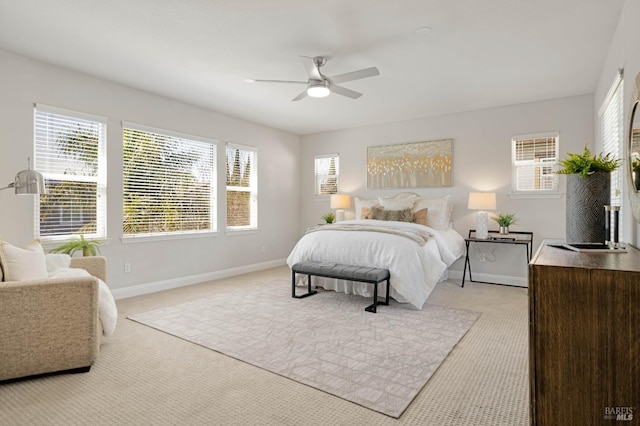 bedroom with light carpet, ceiling fan, and baseboards