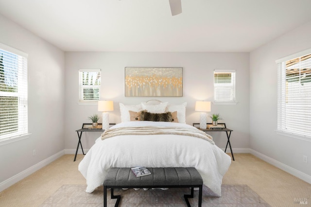 bedroom featuring light carpet, ceiling fan, and baseboards