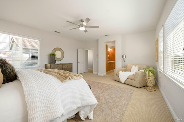 bedroom featuring light carpet, multiple windows, and baseboards