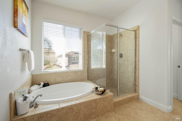 bathroom with a stall shower, a garden tub, and tile patterned floors