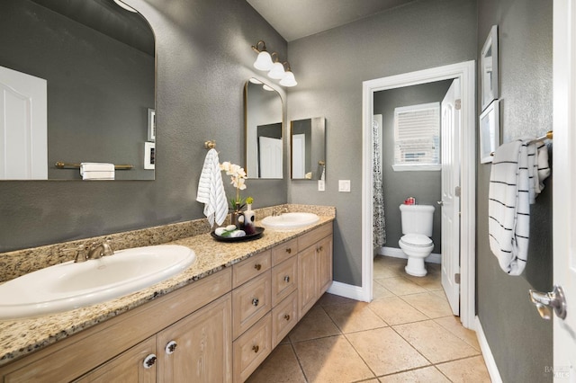 bathroom featuring tile patterned flooring, a sink, toilet, and baseboards