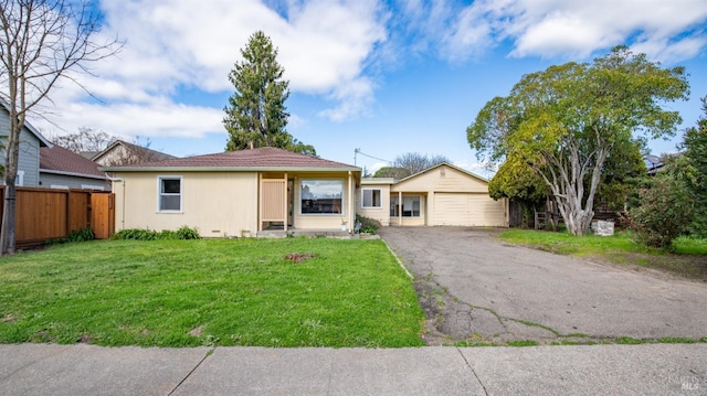 ranch-style home with crawl space, fence, a detached garage, and a front lawn