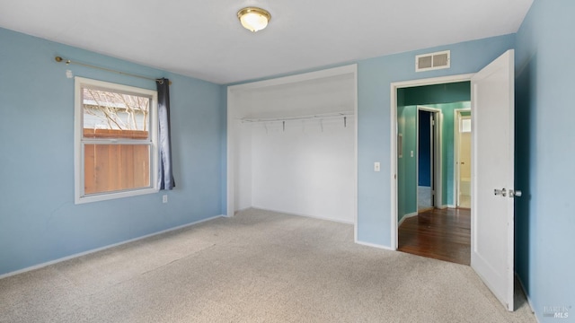 unfurnished bedroom featuring carpet floors, a closet, visible vents, and baseboards