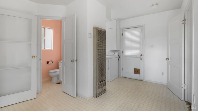 bathroom with toilet, washer / dryer, baseboards, and tile patterned floors