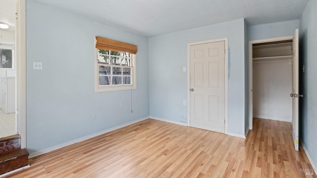 unfurnished bedroom with a closet, light wood-style flooring, and baseboards