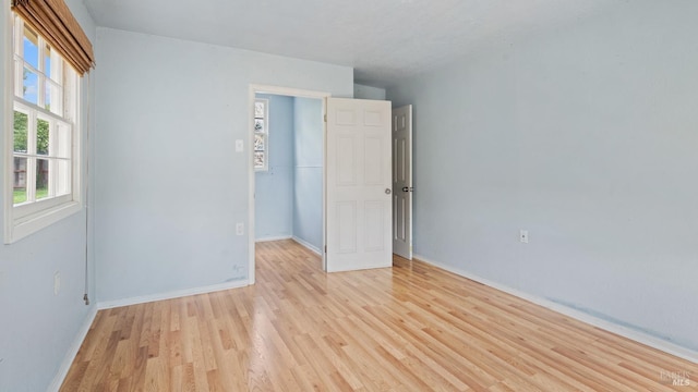 spare room with light wood-style flooring and baseboards