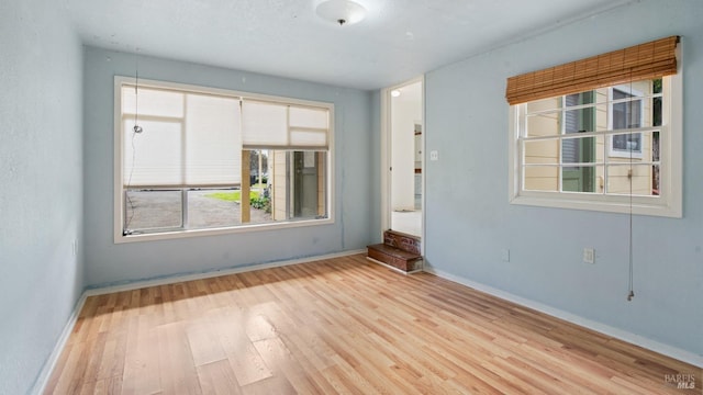 spare room with wood finished floors and baseboards