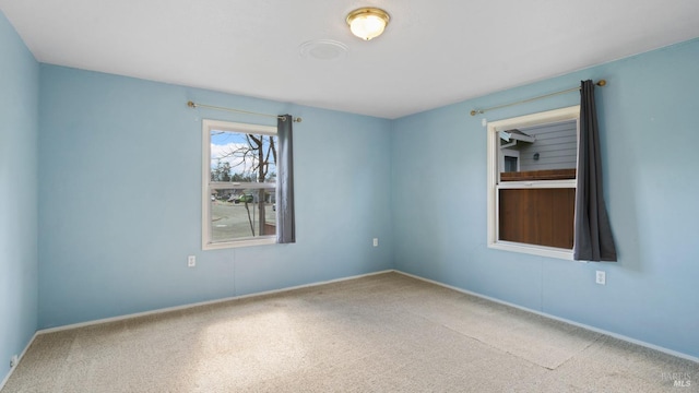 carpeted empty room featuring baseboards