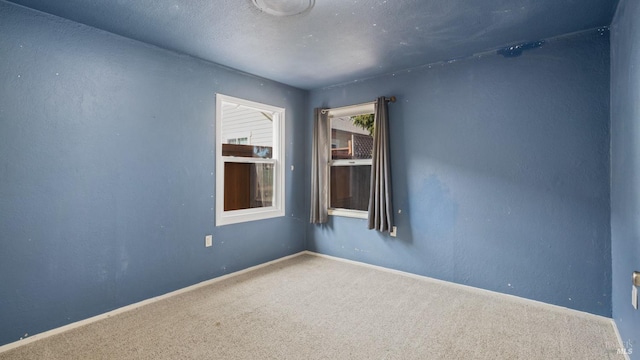 carpeted spare room with baseboards