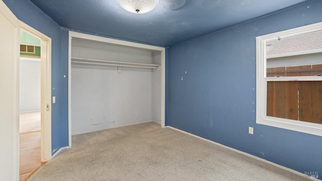 unfurnished bedroom featuring a closet, visible vents, and carpet flooring