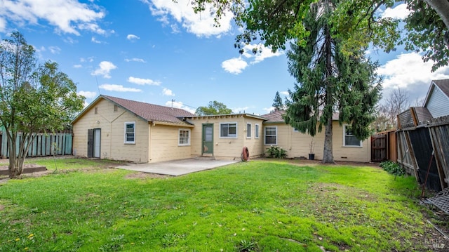 rear view of property featuring a lawn, a patio area, and a fenced backyard