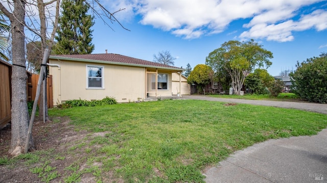 view of front of home featuring driveway, fence, and a front lawn