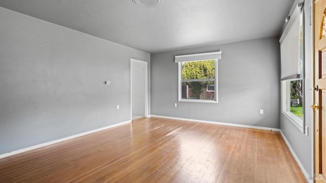 unfurnished room with wood-type flooring and baseboards