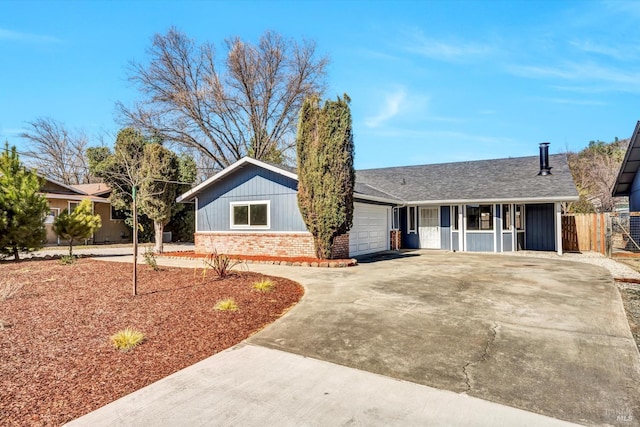 ranch-style house with an attached garage, brick siding, fence, concrete driveway, and roof with shingles