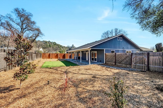 back of property featuring a yard, a fenced backyard, and a patio