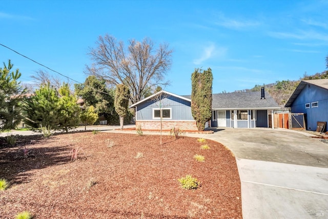 ranch-style house featuring concrete driveway and brick siding