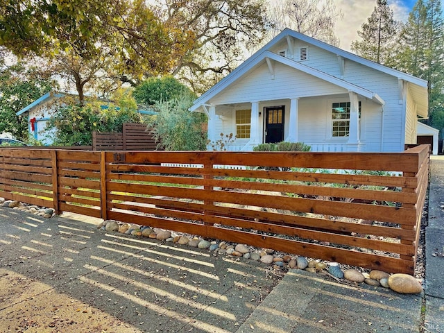view of front facade featuring a porch and a fenced front yard