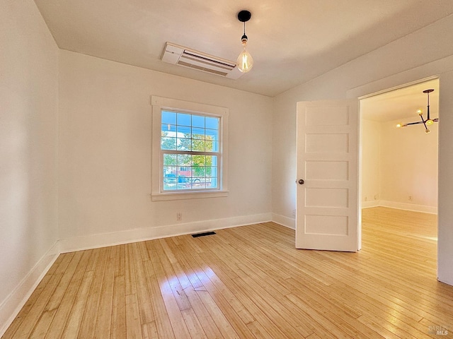 spare room with light wood-style floors, visible vents, and baseboards