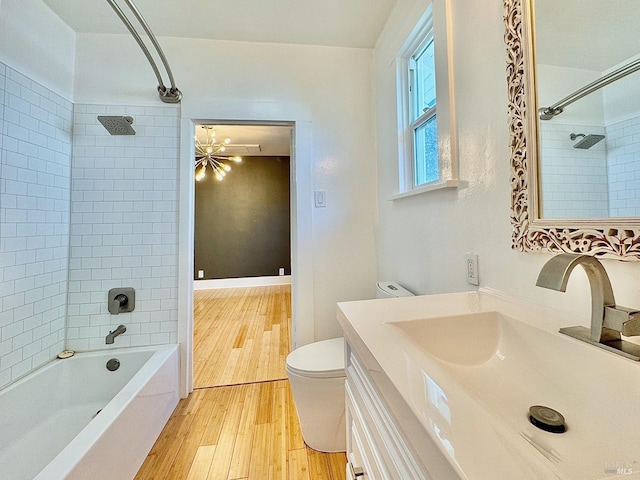 full bath featuring wood finished floors, toilet, vanity, shower / tub combination, and a chandelier