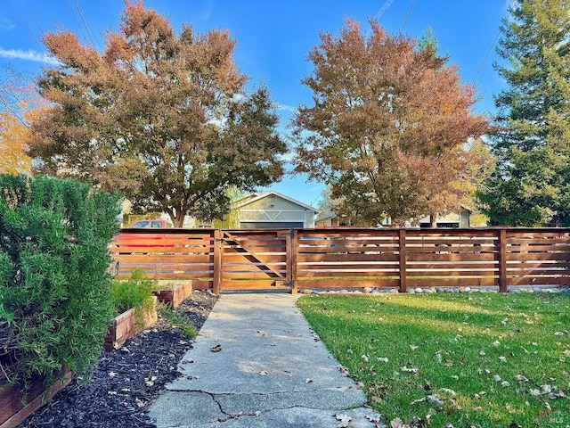 view of gate with fence and a yard