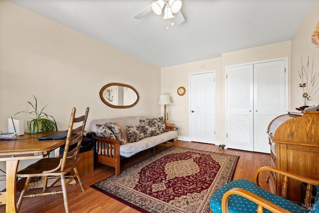 living area with a ceiling fan and wood finished floors