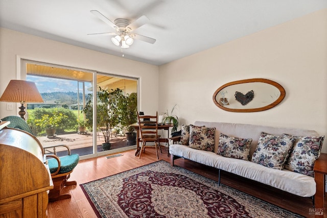 living room featuring ceiling fan, wood finished floors, and visible vents