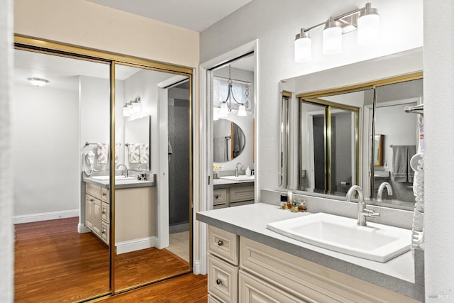 bathroom with two vanities, a sink, and wood finished floors