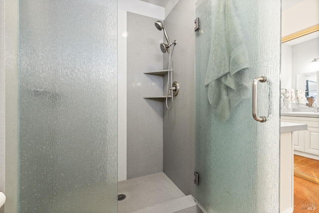 full bath with a stall shower, wood finished floors, and vanity