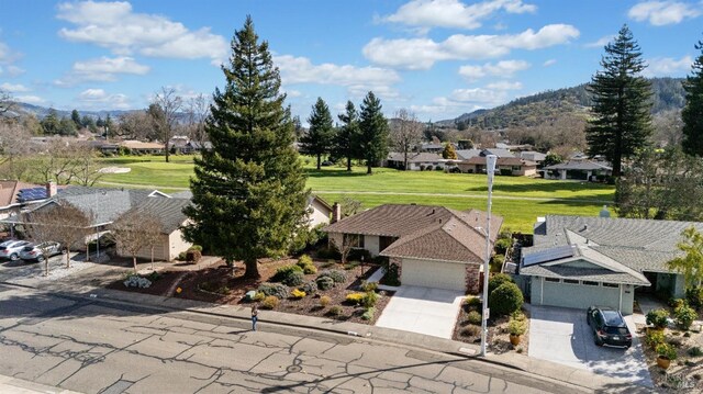 ranch-style home featuring concrete driveway, brick siding, roof with shingles, and an attached garage