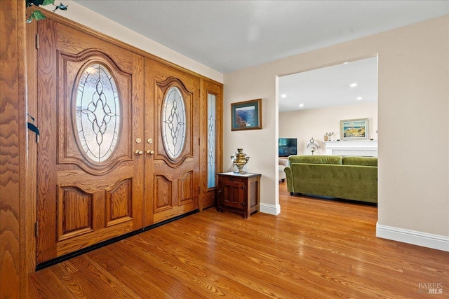 entrance foyer with baseboards and wood finished floors