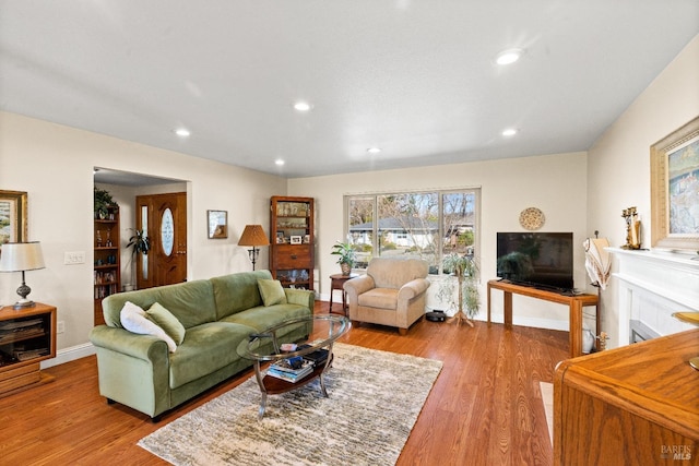 living area with recessed lighting, light wood-style flooring, and baseboards