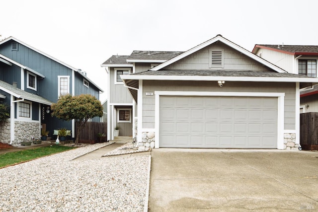 view of front of home with driveway, an attached garage, fence, and a shingled roof