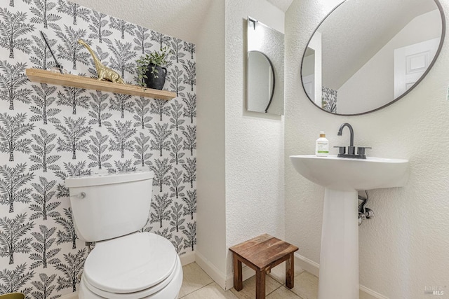 half bathroom featuring baseboards, toilet, and tile patterned floors