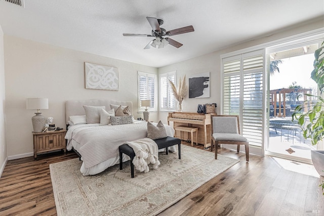 bedroom with access to exterior, visible vents, a ceiling fan, wood finished floors, and baseboards