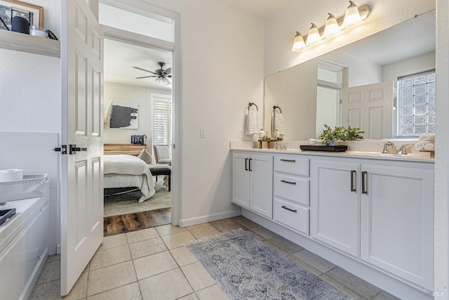 full bathroom with a sink, ensuite bath, double vanity, and a wealth of natural light