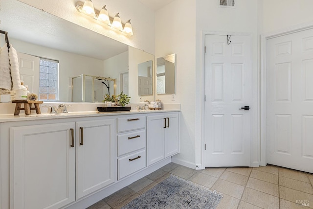 full bathroom featuring double vanity, a stall shower, visible vents, and tile patterned floors