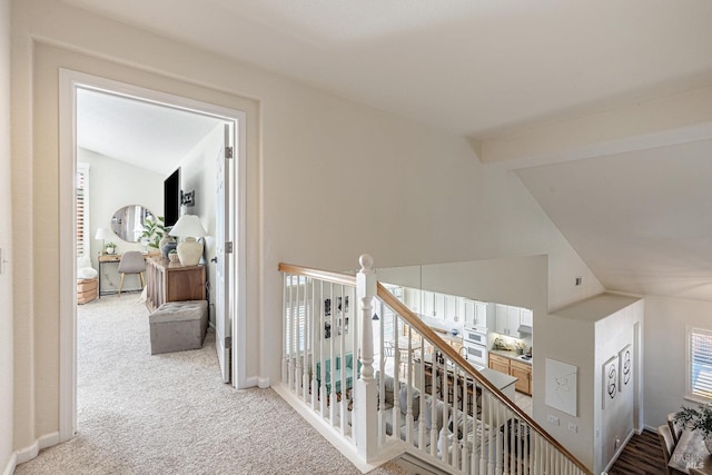 corridor with lofted ceiling and carpet