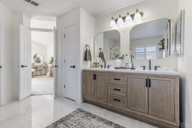 bathroom with double vanity, marble finish floor, visible vents, and a sink