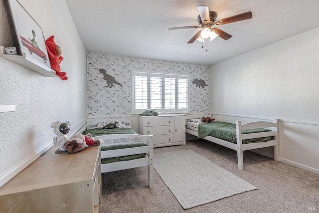 carpeted bedroom featuring a textured ceiling, a textured wall, and ceiling fan