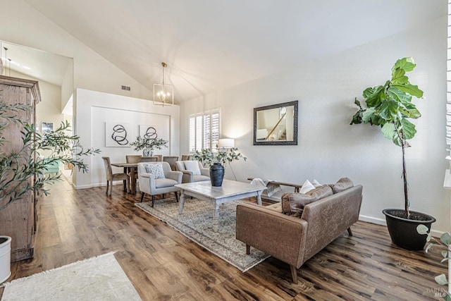 living area featuring lofted ceiling, an inviting chandelier, baseboards, and wood finished floors